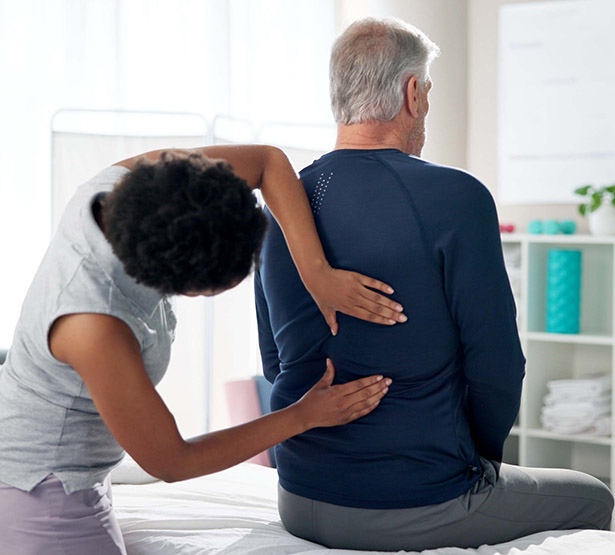 Une femme médecin examine le dos d'un patient - MACSF