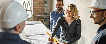 Une femme souriante serre la main d'un entrepreneur - MACSF