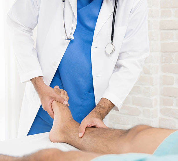 Un médecin examine le mollet de son patient - MACSF