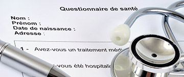 Un stéthoscope et un stylo posés sur un questionnaire médical - MACSF