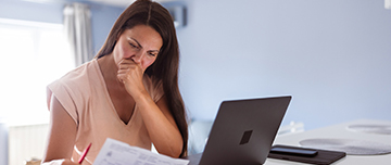 Une femme lisant un document et paraissant inquiète - MACSF