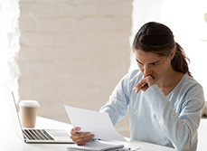 Une femme a son bureau inquiète lit un courrier - MACSF