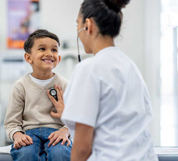Une femme médecin ausculte un jeune patient - MACSF