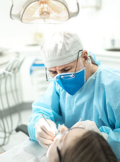 Un chirurgien-dentiste pratique des soins sur une patiente - MACSF