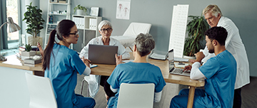 Des professionnels de santé examinent un dossier autour d'une table - MACSF