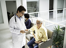 Un médecin discute avec un patient dans la salle d'attente de l'hôpital - MACSF
