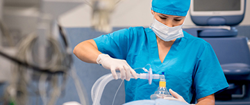 Une IADE applique un masque d'anesthésie sur un patient au bloc - MACSF