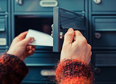Mains d'une femme retirant le courrier de sa boite aux lettres - MACSF