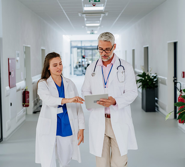 Un médecin et son interne dans le couloir de l'hôpital - MACSF