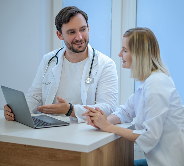Discussion entre deux médecins devant l'ordinateur - MACSF