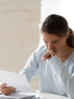 Une femme a son bureau inquiète lit un courrier - MACSF