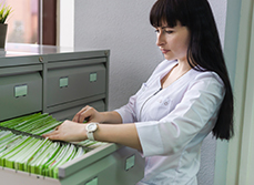 Professionnel de santé cherchant un dossier médical dans le tiroir - MACSF