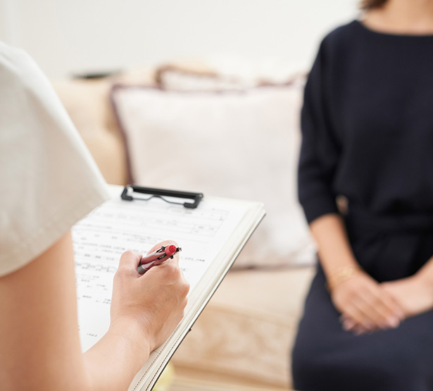 Une infirmière écrit face à une patiente - MACSF