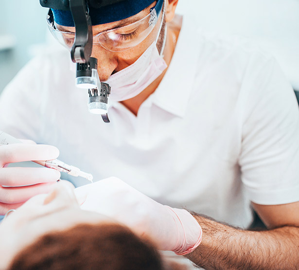 Un chirurgien dentiste effectue des soins sur son patient - MACSF