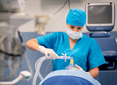 Une IADE applique un masque d'anesthésie sur un patient au bloc - MACSF