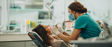 Une femme dentiste prodigue des soins à une patiente - MACSF