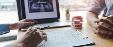 Le chirurgien-dentiste complète le questionnaire médical du patient - MACSF