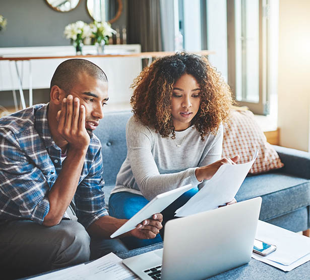 Un couple avec des documents devant leur ordinateur - MACSF