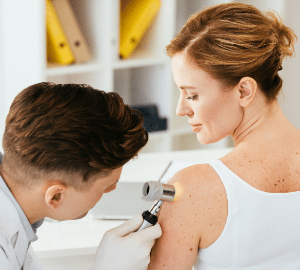 dermatologue analysant un grain de beauté