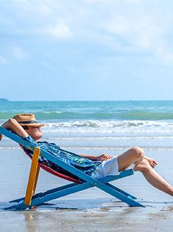 Un homme dans une chaise longue sur la plage - MACSF