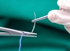 Mains d'infirmier tenant une pince et une aiguille de suture - MACSF