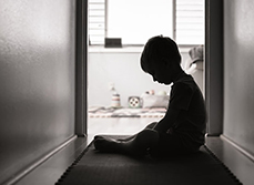 Enfant triste assis dans le couloir de la maison - MACSF
