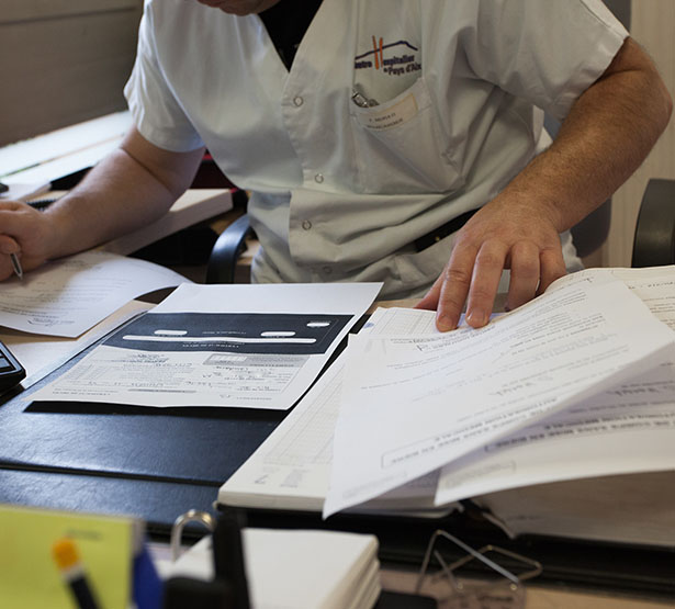 Un homme à son bureau examine des documents - MACSF