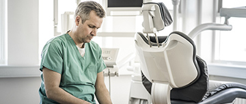 Un dentiste utilise son smartphone au cabinet dentaire - MACSF