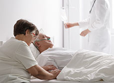 Une femme au chevet de son mari mourant sur le lit d'hôpital - MACSF