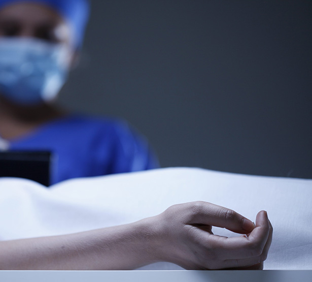 Gros plan sur le bras d'une défunte. Buste du médecin en second plan - MACSF
