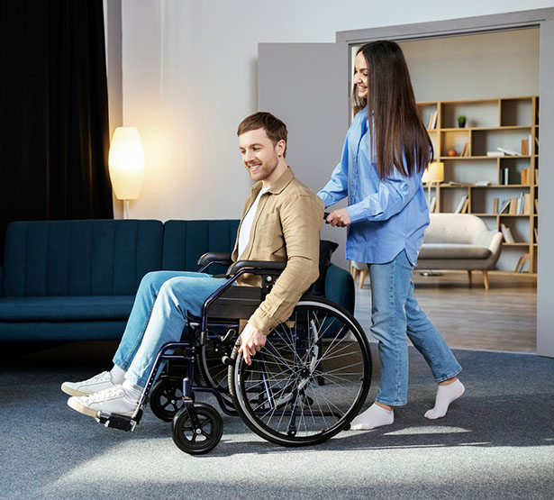 La jeune femme pousse un jeune homme en fauteuil roulant - MACSF