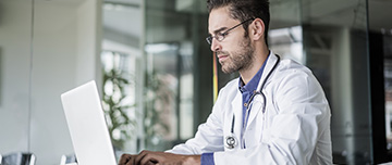 Un jeune médecin devant son ordinateur - MACSF