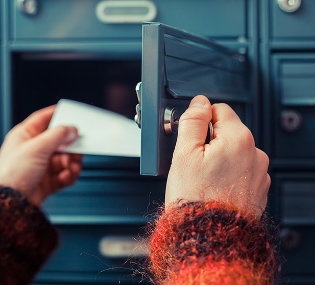 Mains d'une femme retirant le courrier de sa boite aux lettres - MACSF