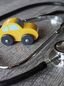 une voiture en bois posée à côté d'un stéthoscope - MACSF