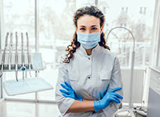 Gros plan sur une dentiste masquée avec son cabinet en arrière plan - MACSF