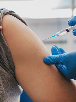 Un infirmier injecte le vaccin dans le bras d'une femme - MACSF