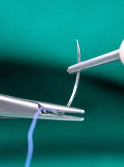 Mains d'infirmier tenant une pince et une aiguille de suture - MACSF