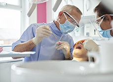 Un chirurgien-dentiste pratique des soins sur une patiente - MACSF