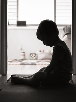 Enfant triste assis dans le couloir de la maison - MACSF