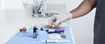 Le dentiste saisit un instrument sur la table - MACSF