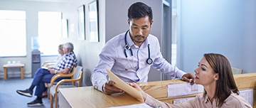 Médecin et réceptionniste discutant du dossier médical – MACSF