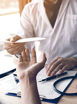 Un médecin tend un document au patient - MACSF