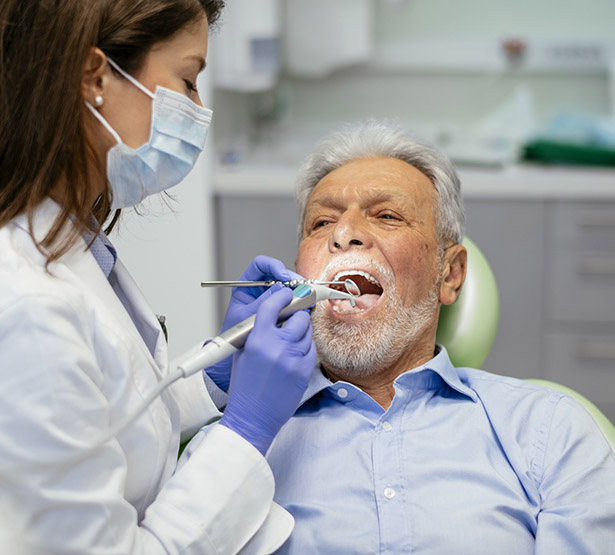 Une femme chirurgien-dentiste soigne un patient - MACSF