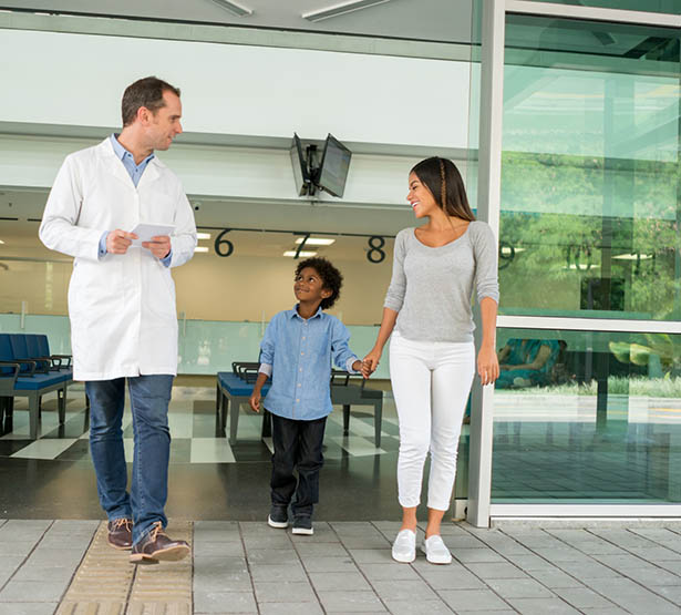 Un enfant marche à côté de sa mère et d'un médecin à l'hôpital - MACSF