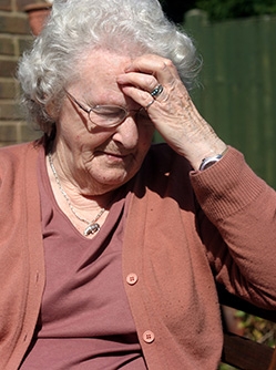 Une dame âgée se tient la tête - MACSF