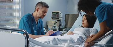 Jeune femme alitée à l'hôpital, entourée de deux soignants - MACSF