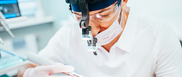 Un chirurgien dentiste effectue des soins sur son patient - MACSF