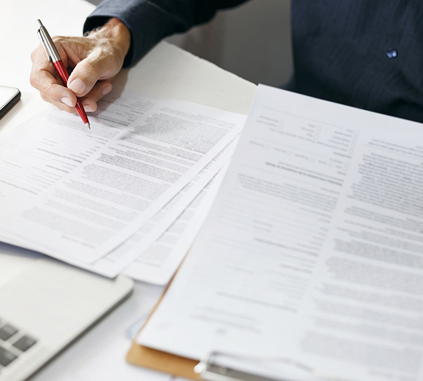 Main d'un homme tenant un stylo au dessus d'un document - MACSF