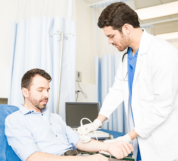 Médecin pratiquant une échographie du bras sur un homme - MACSF