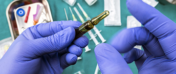 Mains aux gants bleus préparant une dose d'injection - MACSF